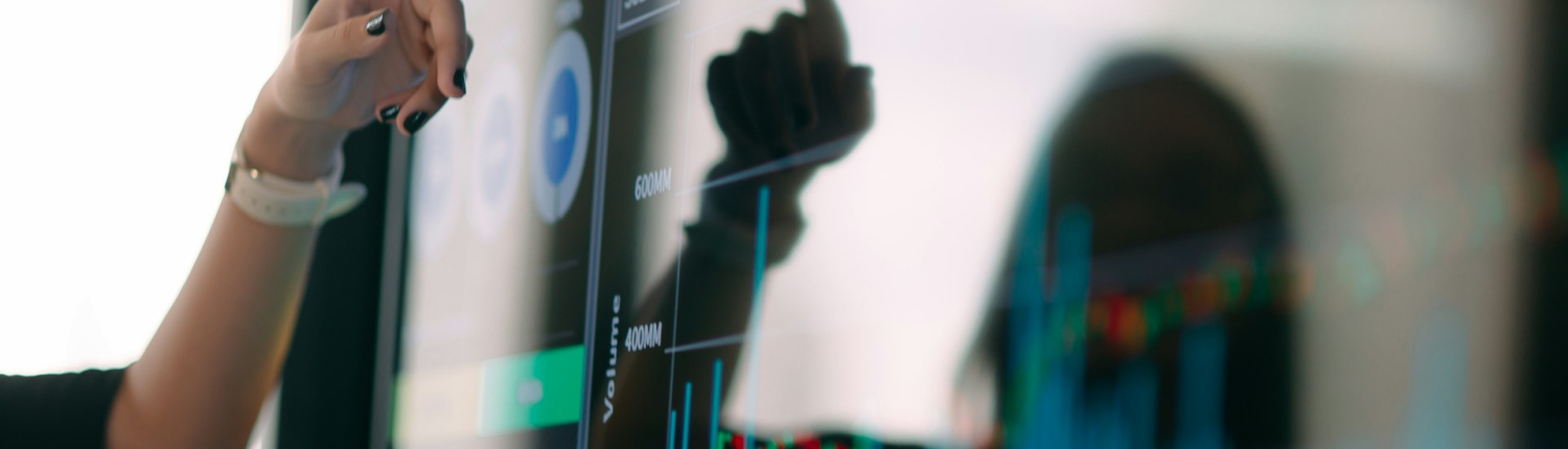 A woman's hand points to a screen with a predictive analysis dashboard.