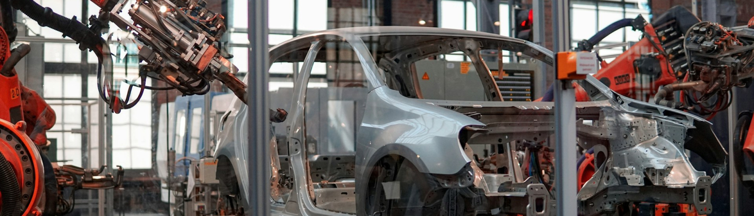 Robotic arms work on a part-built car in a car manufacturing factor