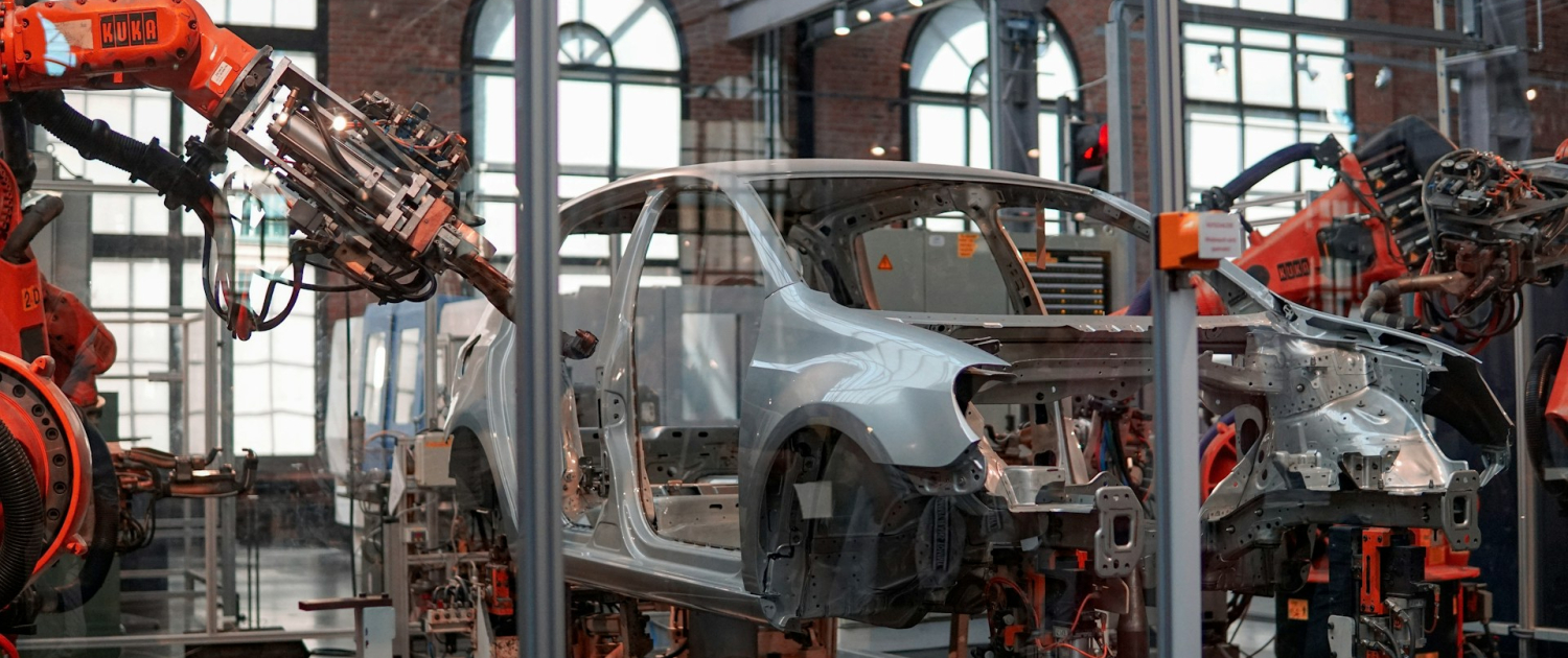 Robotic arms work on a part-built car in a car manufacturing factor