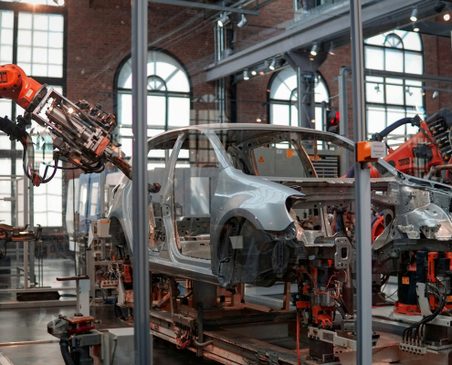 Robotic arms work on a part-built car in a car manufacturing factor